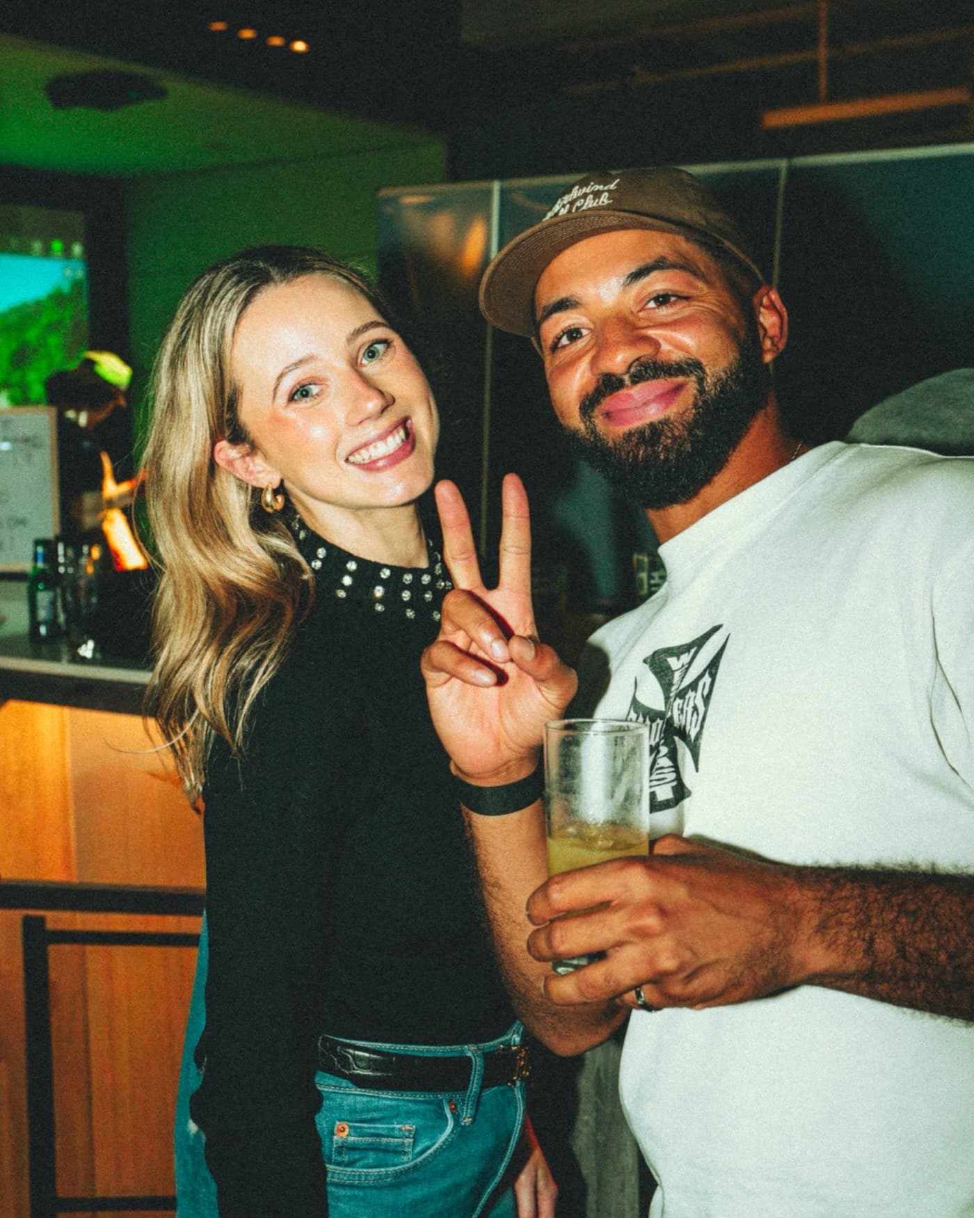 Two guests smiling with drinks at a Caddi Club event night