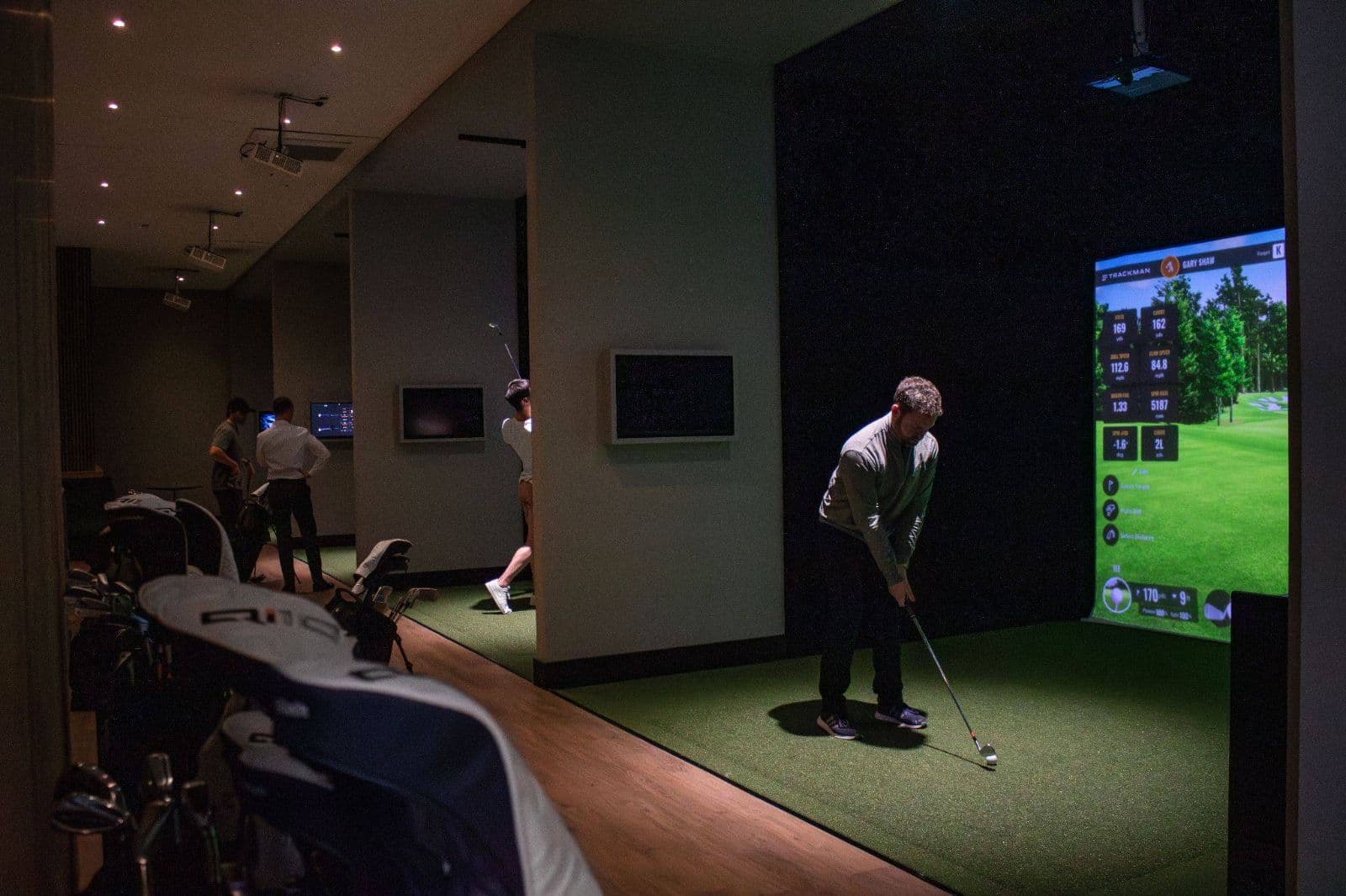 A Caddi Club member playing a TrackMan course in a simulator bay