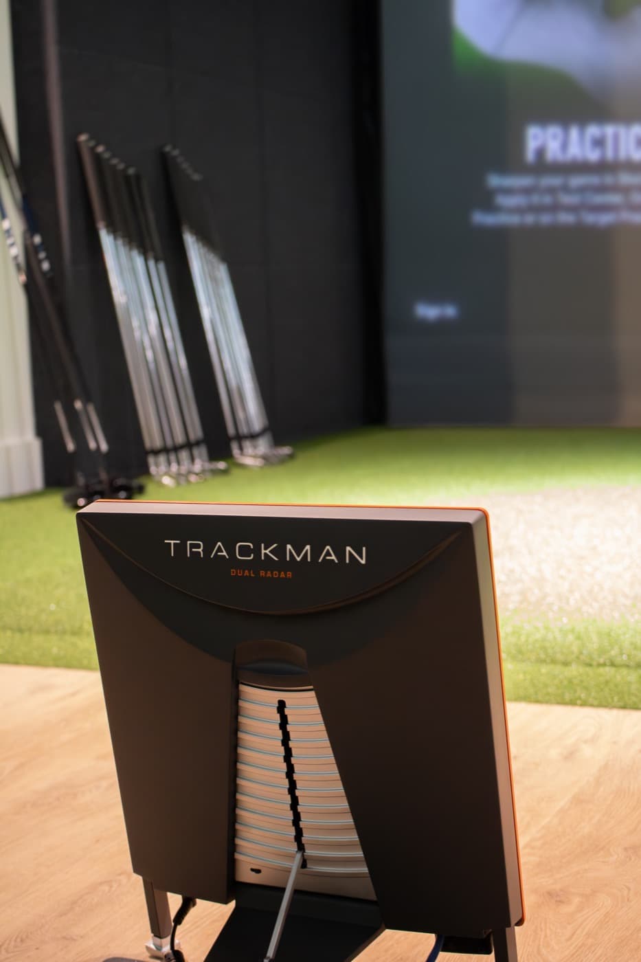 A TrackMan unit behind the hitting mat in a Caddi Club Fulham bay